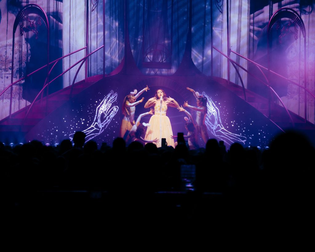 Laufey on stage with the crowd in the foreground